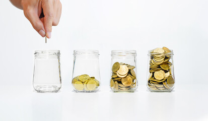 business man hand put coin on glass jar with many coins step growth up on white table against white background. money saving and owner investment concept for business financial.