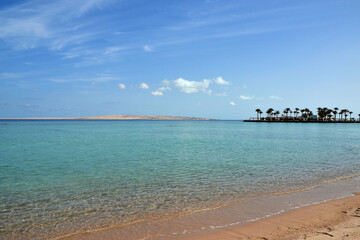 Sandy beach, sea and blue sky with clouds