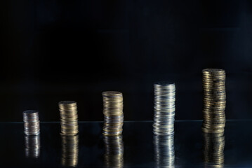Still life from coins in columns on a black background