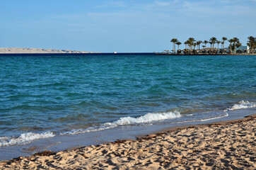 Sandy beach, sea and blue sky with clouds