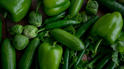 Food background. Bell green peppers, cucumbers, hot green chili peppers, Brussels sprouts, green salad.