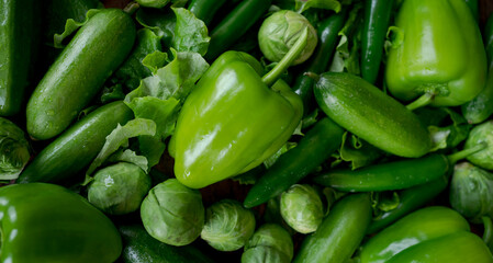Food background. Bell green peppers, cucumbers, hot green chili peppers, Brussels sprouts, green salad.