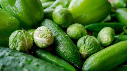 Food background. Bell green peppers, cucumbers, hot green chili peppers, Brussels sprouts, green salad.