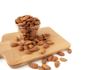 Organic almonds in glass bowl with Wood cutting board and heap almonds isolated on white background for almond nuts can improve health concept.