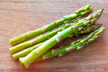 Macro of raw asparagus over a wooden cutting board, 