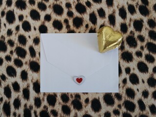 carta de amor/felicitacion y bombon dorado a fondo de estampado de leopardo