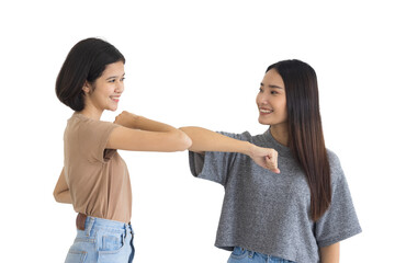 Two Asian teenage girls are Intimate friends greeting each other using elbows. New normal and social distancing to protect the spread of the coronavirus covid-19 on white background.