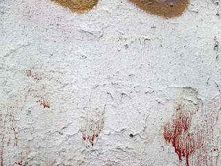 White paint with red streaks. Old flaky surface.