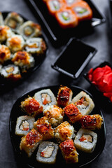 Fresh sushi rolls set on gark background