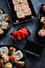 Fresh sushi rolls set on gark background