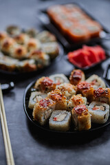 Fresh sushi rolls set on gark background