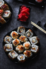 Fresh sushi rolls set on gark background