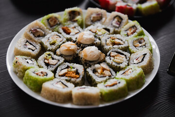 Fresh sushi rolls set on gark background