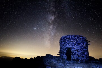 Night view of a nuraghe, ancient Sardinian construction, below a sky full of stars, Sardinia, Italy 