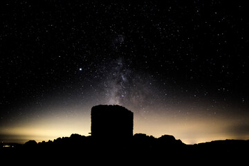 View of a nuraghe below a starry sky at night. Monte Vittoria, Barbagia, Sardegna, italy.
