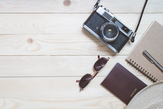 Top view travel accessories on wood texture background. Blogger journey with camera film, hat, sunglasses in summer concept.