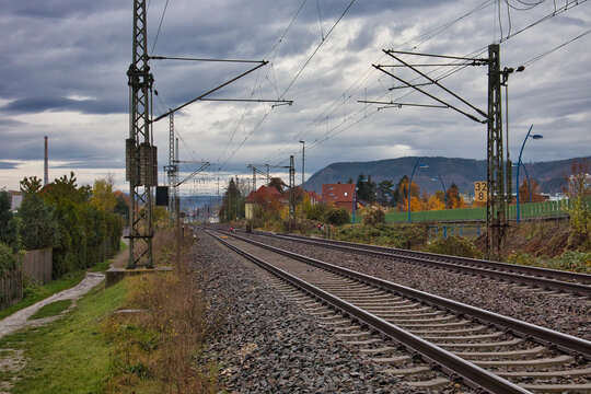Zweigleisige Bahnstrecke mit Oberleitungen in l&auml;ndlicher Region, Eisenbahnschienen f&uuml;hren in die Ferne unter bew&ouml;lktem Herbsthimmel, Bahnhof G&ouml;schwitz, Jena, Th&uuml;ringen, Deutschland