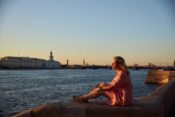 woman sitting on the pier at sunset
