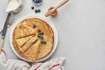 Crepes, thin pancakes or blini with berries in white plate. Top view. Pancake week. Shrovetide....