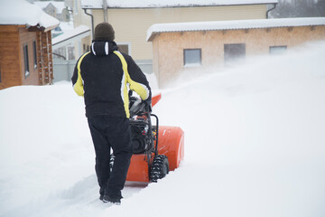 A portable snow blower powered by gasoline. Snow removal in winter.