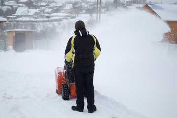 A portable snow blower powered by gasoline. Snow removal in winter.