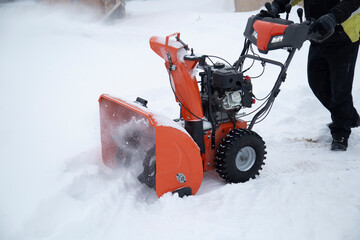 A portable snow blower powered by gasoline. Snow removal in winter.