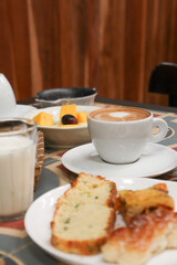cup of coffee on a beautiful table with fruits, cake and milk for a breakfast