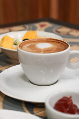 cup of coffee on a beautiful table with fruits and cake for a breakfast