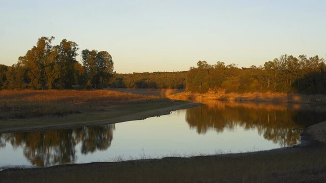 Lake Embalse de Piedra Aguda dam near Olivenza, Spain at sunset with beautiful reflection on the water