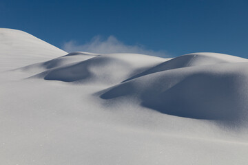 Fototapeta na wymiar white dunes after a snowfall on the Cavalline hill in Elva, Valle Maira - Cottian Alps