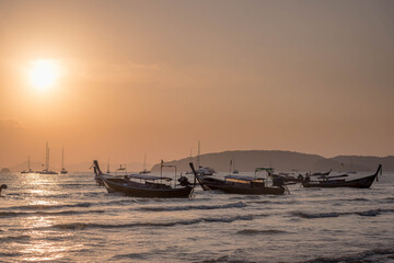 Fototapeta premium Vintage and retro toning of tropical beach with blue sky and clear sea which including of a wooden boat in sunrise time with vintage retro tone. Vacation time as concept.