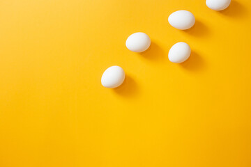 Chicken white eggs on a yellow background.