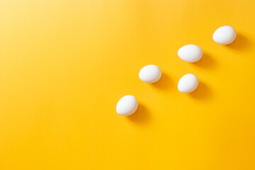 Chicken white eggs on a yellow background.