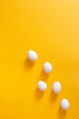 Chicken white eggs on a yellow background.