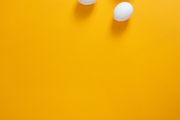 Chicken white eggs on a yellow background.