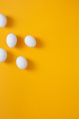 Chicken white eggs on a yellow background.