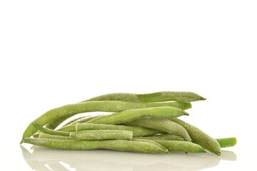 Frozen organic green beans, close-up, isolated on white.