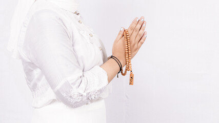 Asian muslim woman wearing prayer beads welcoming guests or Ied Fitr Greeting in white background