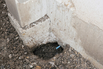 circle dig hole in soil ground install plastic blue tube line. repair broken pvc under foundation ...