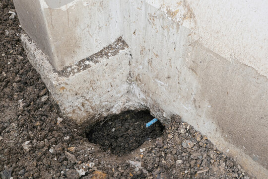 circle dig hole in soil ground install plastic blue tube line. repair broken pvc under foundation  house