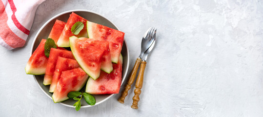 Ripe and sweet watermelon pieces on light backrgound. Top view. Long banner. Copy space. Summer...