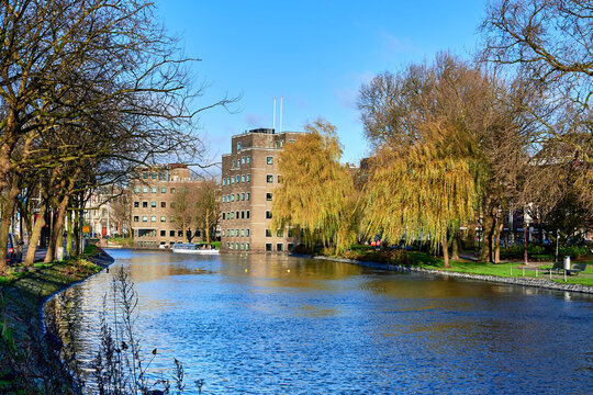 Around the canals of Amsterdam, in the foreground a ferry that takes tourists around. Holland - Powered by Adobe