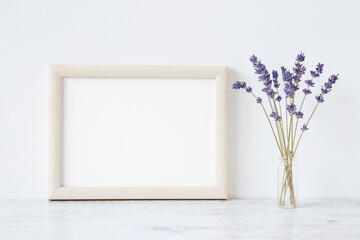 Dried purple lavender in glass vase on shelf at light gray wall background. Empty place for...
