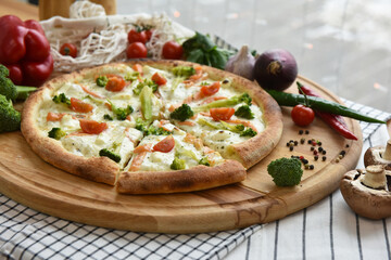 pizza with a toasted crust and vegetables on a wooden stand