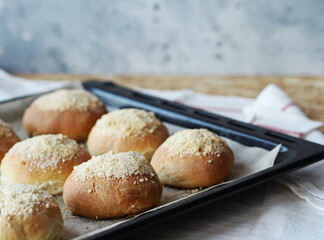 Homemade buns on a black baking sheet from the oven. Ready to eat.Home cooking concept. Bread and rolls.