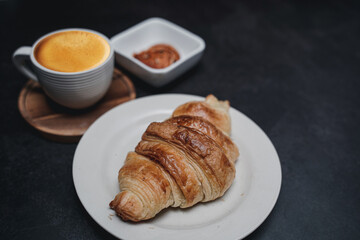 cup of coffee and Fresh baked croissant on old kitchen table. Top view with copyspace for your text.