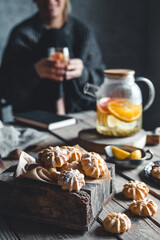 Woman is sitting with Hot tea with fresh grapefruit on wooden tablet. Healthy drink, Eco, vegan.