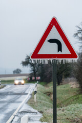 bend in road sign in ice and snow