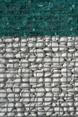  part of a fence of white stone and glass in a wire. background or texture       