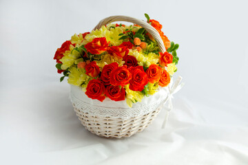beautiful light wicker basket with yellow and red flowers. holiday, spring, congratulations